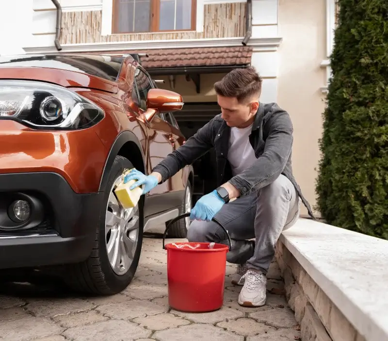 Lavage auto à domicile Vieillevie : professionnel intervenant sur un véhicule